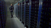 Still image of Dr. James Beacham walks past CERN ATLAS servers